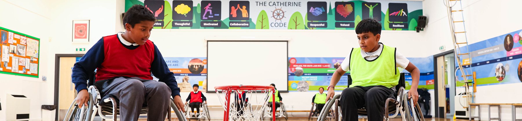 Pupils playing wheelchair basketball in a school hall